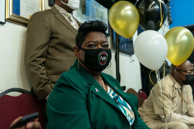 Darcel Clark wears a mask with the letters "NAN" while seated